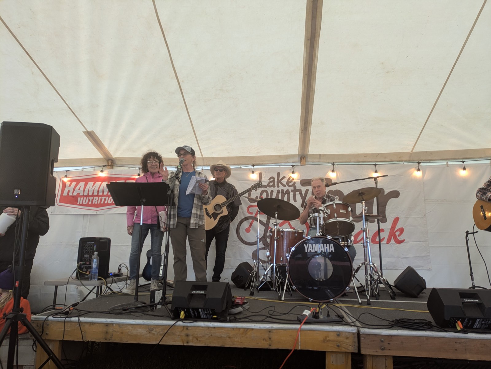 A live band performing on stage under the Lake County Tour de Outback festival tent